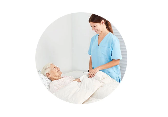 Pflegerin mit Patientin Umlagern bei Dekubitus