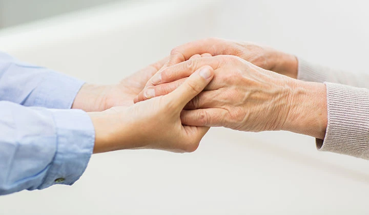 Pflegerin hält Hand von Seniorin Wundpflege von Pflegebedürftigen kann in Kursen erlernt werden