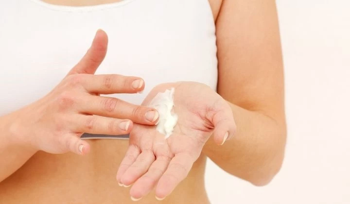 Frau verteilt Creme auf Hand Frau verteilt Creme auf Hand